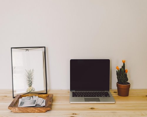 Person relaxing and leaning back from a clean minimalist computer desk